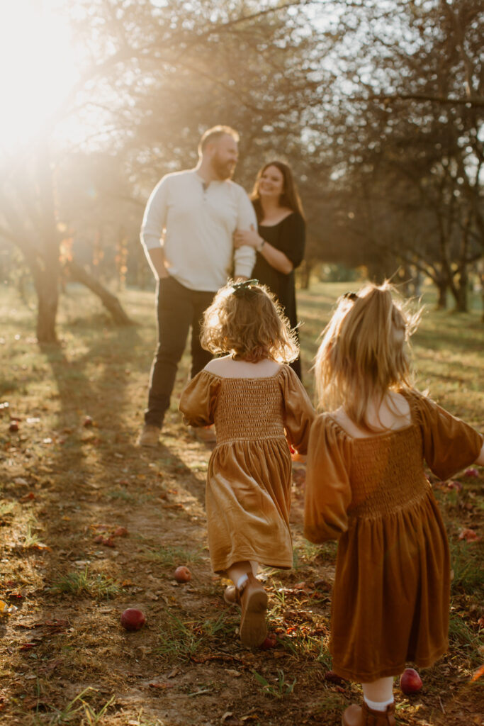 Parents embracing while their children play nearby at Prairie Wolf Park.