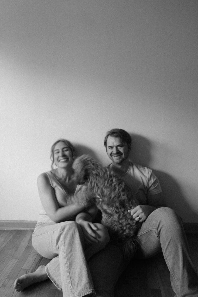 Husband and wife sharing a candid laugh during an indoor portrait session.