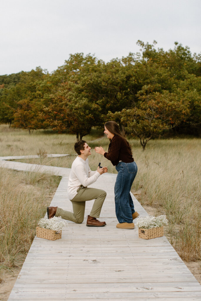 Man getting down on one knee during a surprise proposal at Rosy Mound.