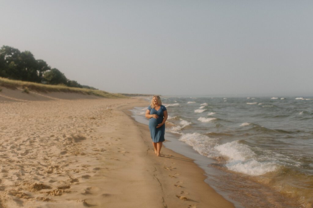 Mother walking along Michigan beach.